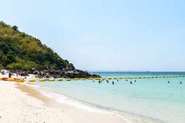 Pattaya, Tayland - 7 Mart 2024: Koh Larn adasındaki tropik bir sahil ve mavi denizin manzarası. Turist ya da Gezgin grubu ya da sahildeki birçok kişi. Tatil, Yaz, Tatil, Doğa, Rahatlama.