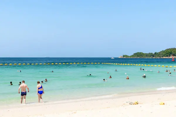 Pattaya, Tayland - 7 Mart 2024: Koh Larn adasındaki tropik bir sahil ve mavi denizin manzarası. Turist ya da Gezgin grubu ya da sahildeki birçok kişi. Tatil, Yaz, Tatil, Doğa, Rahatlama.