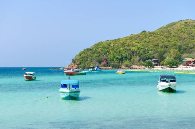 Pattaya, Tayland - 7 Mart 2024: Koh Larn adasında tropik bir sahil ve mavi denizin manzarası. Sahilde bir grup turist ya da gezgin. Tatil, Yaz, Tatil, Sürat teknesi, Gemi, Etkinlik.
