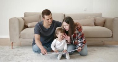 Aile, ebeveynlik ve insanlar kavramı - mutlu anne, baba ve bebek daugter okuma kitap evde.