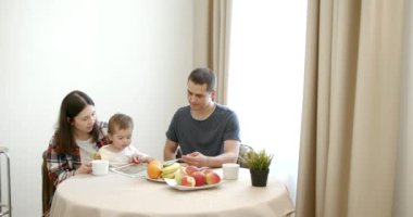 Aile, yemek ve insanlar kavramı - mutlu anne, baba ve kızı evde kahvaltı.