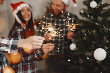 Gruptaki gençlerin mutluluğu. İnsanlar Noel 'i ve yeni yılı kutlar. Bengal ışıkları olan arkadaşlar evde..