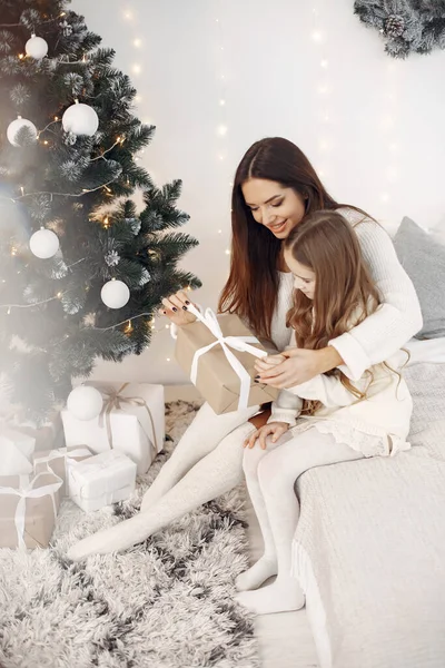 stock image People reparing for Christmas. Mother playing with her daughter. Family sitting on a bed. Little girl in a white dress.