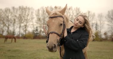 Genç ve güzel bir kız doğada ata sarılıyor. At sever..