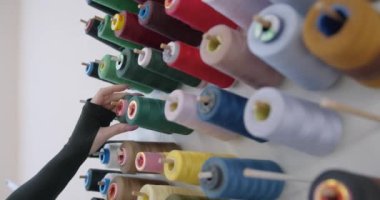 Tasarım stüdyosunda çalışan ve dikiş işi seçen bir kadın. Tekstil fabrikası ayarları.