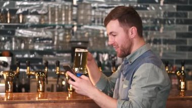 Happy man holds a glass of beer in a bar. Drinking alcohol. Weekend concept.