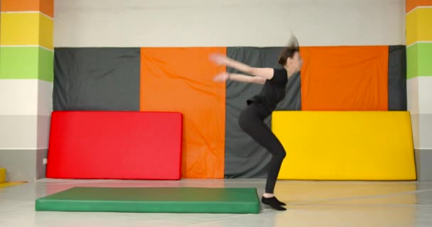 Mladá Žena Černém Kostýmu Dělá Gymnastiku Pozpátku Nastavení Barevného Pokoje — Stock video