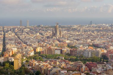 Barselona, İspanya. 3 Ekim 2023. Sagrada Familia, hareketli şehir manzarası, kendine özgü W Oteli (Vela Hotel), güneşle öpülmüş plaj ve uzaktaki gök mavisi Akdeniz gibi ikonik simgelere sahip tepe noktasından panorama