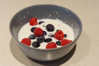 Böğürtlen: Yüzen Yabanmersini ve Ahududu ile doldurulmuş Kumis. Koyu kırmızı yaban mersini ve ahududu karışımıyla dolu gri bir kase.