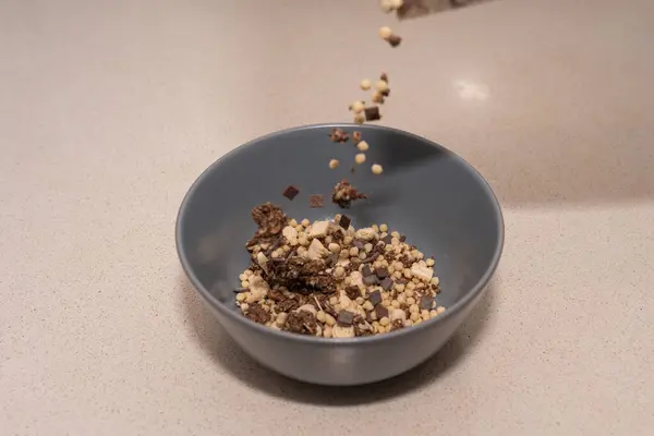 Koyu çikolatalı mısır gevrekleri gri bir kasede servis edilir ve bazı parçalar hızla donar.