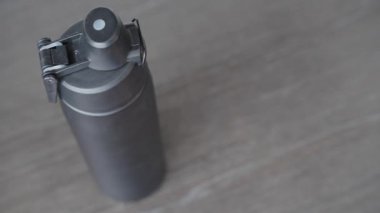 Ellerini uzat ve siyah bir su şişesini tut. Susuzluğun önemini vurgula.