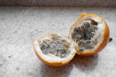Yarı yarıya Tatlı Granadilla içinde tohumlar olan Açık Deniz Kabuğu ve Pulp 'u gösteriyor