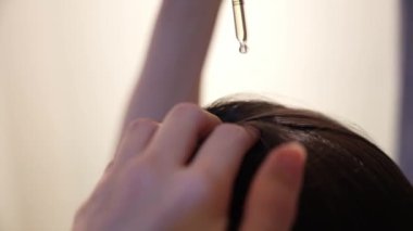 Bir Düşüren ve Elleri kullanarak Kafa derisine Dermatolojik Serum uygulayan Kadının Yakın Çekimi