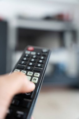El Tutma TV Uzaktan Kumandası Arka plandaki Bulanık TV 'yi Gösteriyor