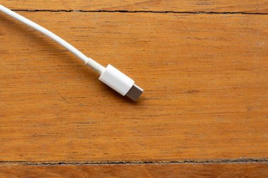 Tahta zemin üzerinde Ample Kopyalama Boşluğu olan beyaz USB tip-C Kablo