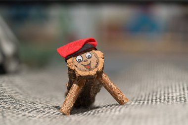 Şenlikli bir Katalan Caga Ti (Ti de Nadal) figürü, ahşap bir kütükten el yapımı, kırmızı bir şapka takıyor ve gülümseyen bir surat takıyor.