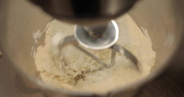 Profesyonel bir elektrikli mikserde hamur hazırlığı. Profesyonel hamur karıştırıcı. Modern aletler mutfakta.