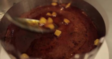 Profesyonel bir pastacının çikolatalı pastasını hazırlarken çikolatalı pastaya karamelize elma ekleme süreci. 4k 'da yakın çekim, UHD. Lezzetli yemek..