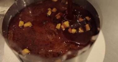 Profesyonel bir pastacının çikolatalı pastasını hazırlarken çikolatalı pastaya karamelize elma ekleme süreci. 4k 'da yakın çekim, UHD. Lezzetli yemek..