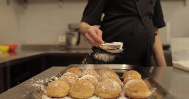 Uma Confeiteira Polvilha Açúcar Biscoitos Dispostos Uma Superfície Metálica Para — Vídeo de Stock