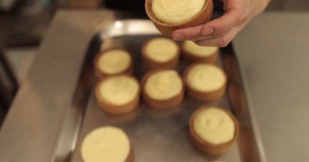 用慕斯制作焦糖 在涂奶油的时候 糕点主厨手里拿着一个小馅饼 糕点厨师用白色的慕斯装饰防水布 — 图库视频影像