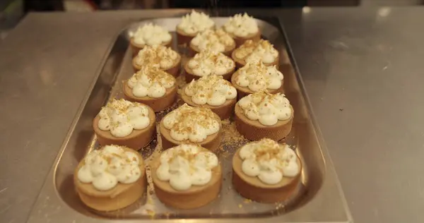 Mini tart yapma süreci. Mini tartları rendelenmiş fındıklarla süsleyip serp..