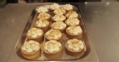 Mini tart yapma süreci. Mini tartları rendelenmiş fındıklarla süsleyip serp..