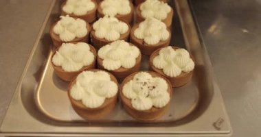 Metal tepside çikolata parçacıkları serpiştirilmiş mini tartlar. Profesyonel bir şekercinin işi.