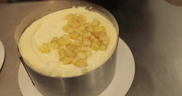 Cooking an apple pie, laying out sliced apples on a tart during the cooking process.