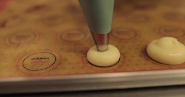 クリームをベーキングトレイの表面に絞る調理用注射器のクローズアップ 調理用シリンジを使用したケーキの調理 — ストック動画