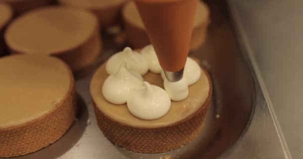 料理用注射器を使用してクリームでタルトを飾る 専門の菓子の台所 プロの菓子によるタルトの大量装飾 — ストック動画