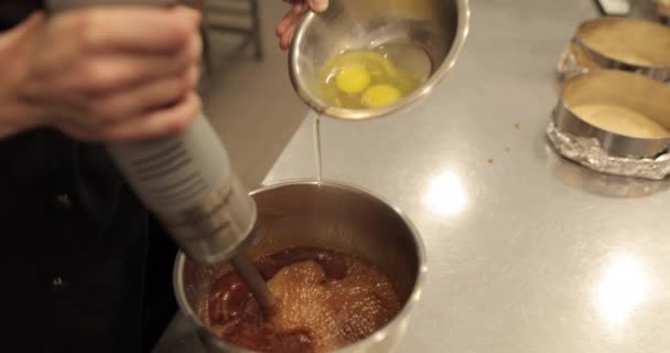 在浸渍搅拌机运行时 将鸡蛋加入碗中 在专业厨房准备糕点面团 — 图库视频影像