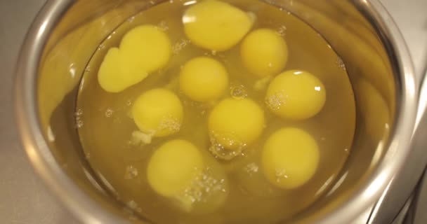 익지않는 달걀은 직업적인 생과자 부엌의 테이블에 그릇으로 분해됩니다 — 비디오