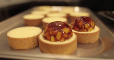 Profesyonel bir pastacının masasındaki turtalar elma reçeli ile süslenir..