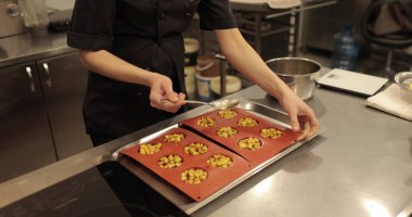 Elma tatlılarını silikon pişirme tepsisinde hazırlamak. Profesyonel bir pastacının işi sırasında silikon tepsiyi doğranmış elmalarla doldurmak.