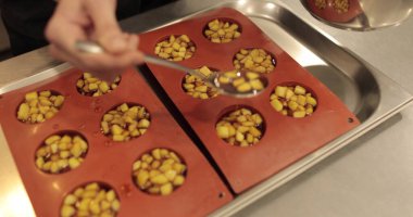 Elma tatlılarını silikon pişirme tepsisinde hazırlamak. Profesyonel bir pastacının işi sırasında silikon tepsiyi doğranmış elmalarla doldurmak.