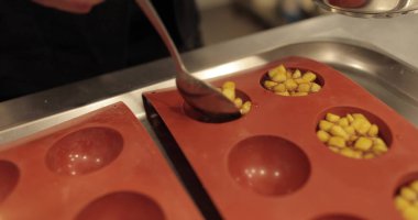 Elma tatlılarını silikon pişirme tepsisinde hazırlamak. Profesyonel bir pastacının işi sırasında silikon tepsiyi doğranmış elmalarla doldurmak.