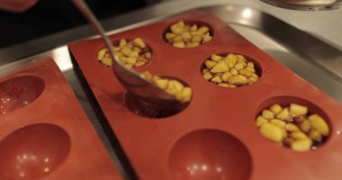 Elma tatlılarını silikon pişirme tepsisinde hazırlamak. Profesyonel bir pastacının işi sırasında silikon tepsiyi doğranmış elmalarla doldurmak.