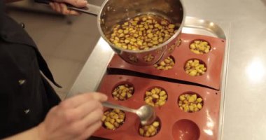 Elma tatlılarını silikon pişirme tepsisinde hazırlamak. Profesyonel bir pastacının işi sırasında silikon tepsiyi doğranmış elmalarla doldurmak.