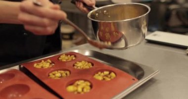 Elma tatlılarını silikon pişirme tepsisinde hazırlamak. Profesyonel bir pastacının işi sırasında silikon tepsiyi doğranmış elmalarla doldurmak.