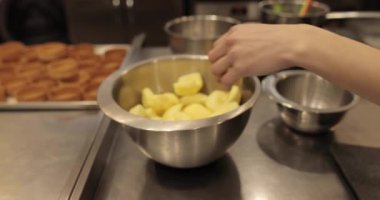 Profesyonel bir pastanede elma tatlısı yapmak için elmaları küp küp kesen kadın ellerine yakın plan..