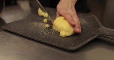 Profesyonel bir pastanede elma tatlısı yapmak için elmaları küp küp kesen kadın ellerine yakın plan..