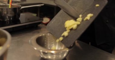 Profesyonel bir pastanede elma tatlısı yapmak için elmaları küp küp kesen kadın ellerine yakın plan..