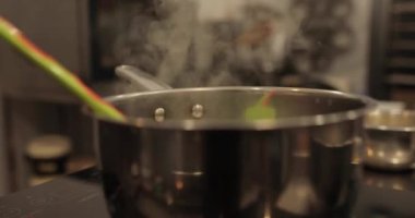 Profesyonel bir pasta mutfağında elma tatlısı hazırlarken ocakta elmalı metal bir tencere ısıtılır.