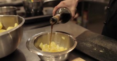 Profesyonel bir pasta mutfağında elma tatlısı hazırlarken ocakta elmalı metal bir tencere ısıtılır.