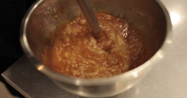 Çikolatalı mus çırpmak, el blendırıyla jöle sürmek. Profesyonel bir mutfakta betel kasesinde mikserin yakın plan görüntüsü.