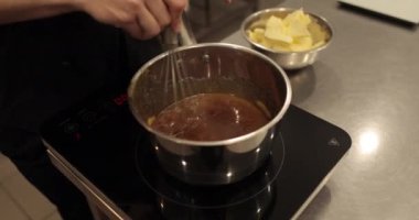 Tatlı yapmak için çikolatalı mousse 'a tereyağı ekleyip karıştırıyorum. Çikolata hazırlama, profesyonel mutfak, fırın, şekerleme