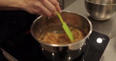 Tatlı hazırlarken sobanın üstünde silikon spatulayla çikolatalı mus karıştırmak.