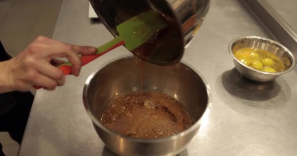 Een Banketbakker Keuken Giet Chocolademousse Van Een Steelpan Een Kom — Stockvideo