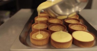 Pasta şefi tartları beyaz kremayla doldurur. Profesyonel bir şekerlemecinin işi. Böğürtlenli tatlı tartlar hazırlıyoruz. Lezzetli bir tatlı..